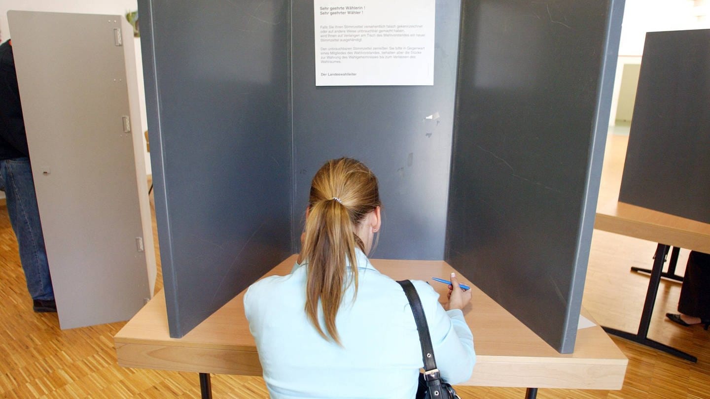 Junge Frau in Wahlkabine (Foto: IMAGO, photothek)
