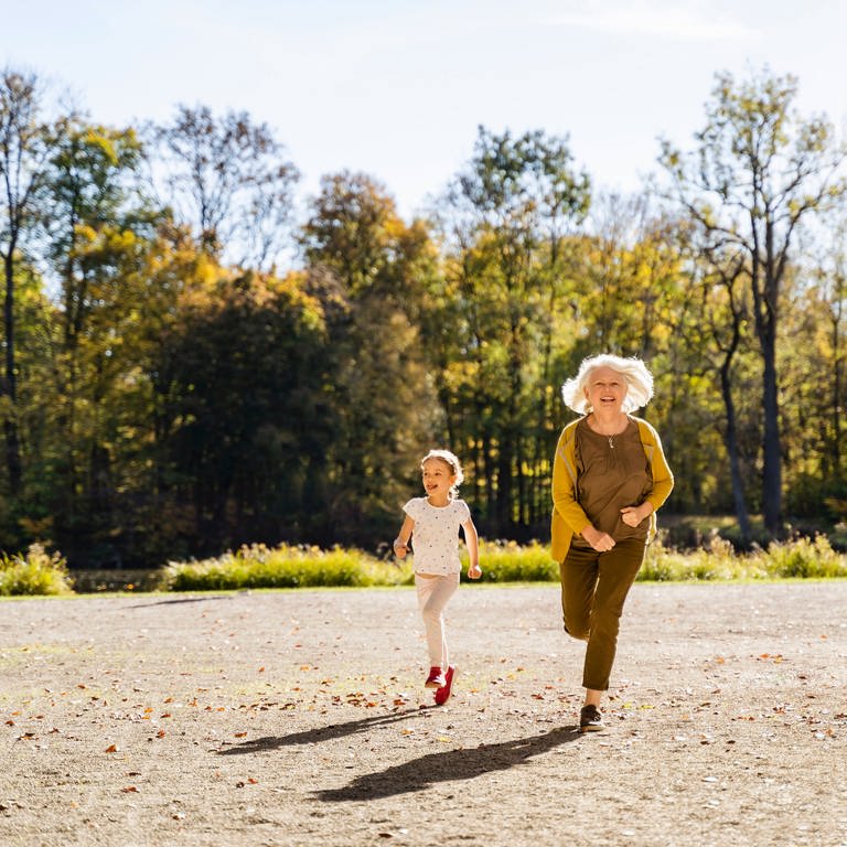 Das Bild zeigt eine ältere Frau und ein kleines Mädchen, die nebeneinander laufen. (Foto: IMAGO, Westend61)
