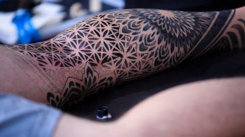 Auch ein Tattoo, welches nur mit schwarzer Farbe gestochen wird, schützt nicht vor gesundheitlichen Risiken. (Foto: IMAGO, Imago images / Belga)