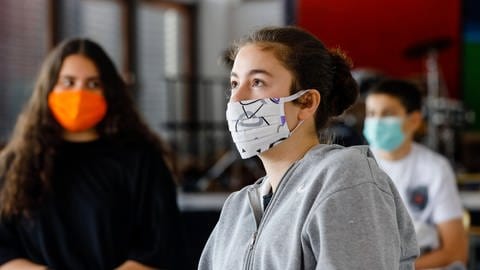 Nur in einzelnen Bundesländern müssen Schüler*innen auch im Unterricht eine Maske tragen. Das Tragen von Masken kann möglicherweise vor schwereren Verläufen von Covid-19 schützen.