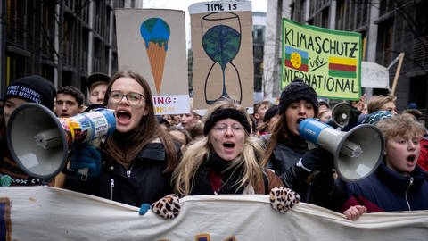 "Fridays for Future" Demonstrierende mit Megafonen und selbstgemalten Schildern: Weltweit – und vor allem in Deutschland – fanden Medien großes Interesse an den Klimaprotesten der Jugendlichen und am Narrativ „Alt gegen Jung“
