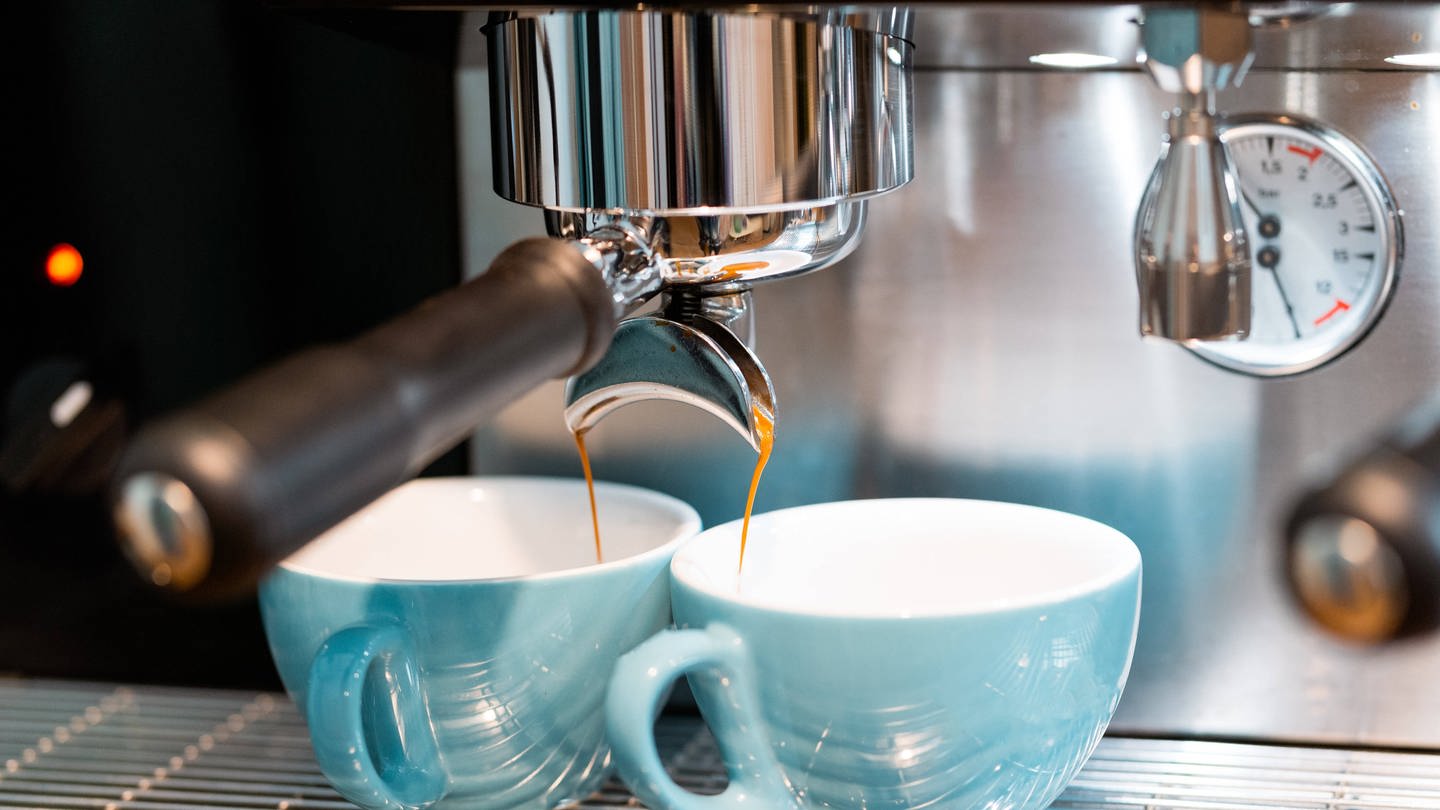 Zwei blaue Tassen unter Espressomaschine: Warum schmeckt Espresso anders als Filterkaffee? (Foto: IMAGO, IMAGO / Addictive Stock)