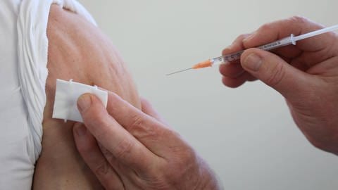 Ältere Person erhält eine Impfung in den Oberarm (Foto: IMAGO, IMAGO / Frank Sorge)