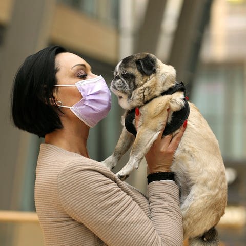 Frau mit Hund - Auch Tiere können sich mit Coronaviren infizieren.