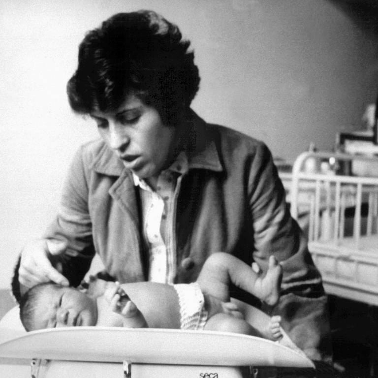 Die Mutter streichelt ihren Sohn Oliver in der Frauenklinik der Universität Erlangen kurz nach der Geburt.