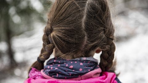 Hinterkopf eines Mädchens mit braunen Zöpfen. (Foto: IMAGO, IMAGO / photothek)