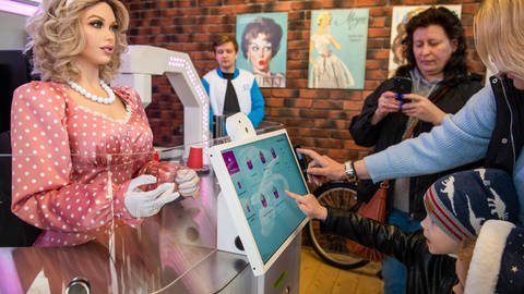 Menschen besuchen die Eröffnung des Cyber-Cafés Dunyasha im Gorki-Park, wo ein humanoider Roboter Eis und Getränke serviert. (Foto: IMAGO, IMAGO / ITAR-TASS)