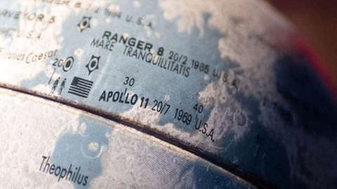 Mond-Globus aus Metall mit einer Markierung des Landeplatzes von Apollo 11 (Foto: dpa Bildfunk, Foto: Daniel Naupold/dpa -)