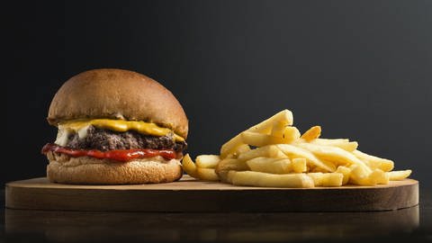 Ein Burger und Pommes auf einem Brett (Foto: pixabay/Fotorech)