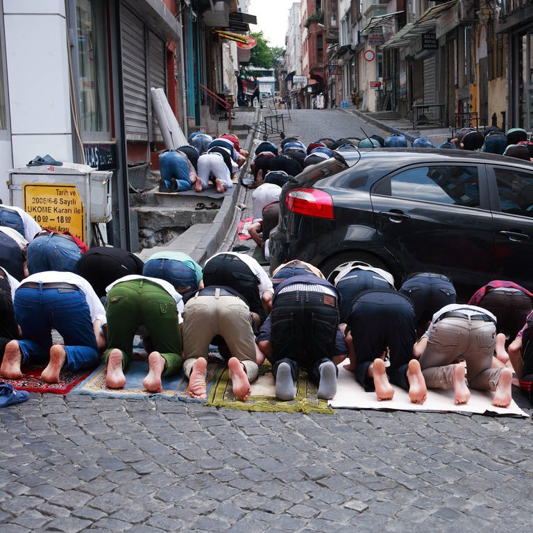 Muslime beim Gebet auf der Straße zwischen Autos