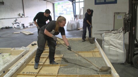Das Team der Hochschule in Biberach füllt Kies auf die Holzplatten, die später die Decke bzw. den Boden bilden sollen. (Foto: SWR)