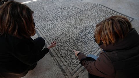 Archäologen illustrieren das Mosaik im Haus von Gemma nach der Restaurierung im archäologischen Gebiet von Herculaneum. (Foto: IMAGO, IMAGO / Independent Photo Agency Int.)