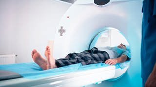 Ein Mann wird in ein MRT Gerät geschoben