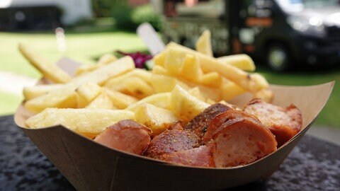 Teller mit Currywurst und Pommes