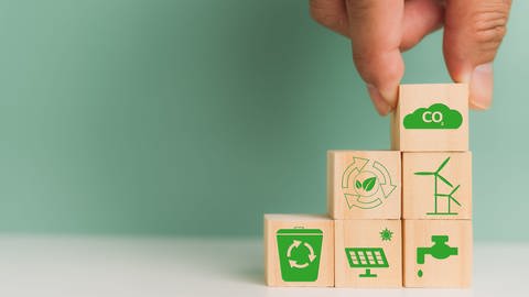 Gestapelte Bauklötze zeigen die Symbole einiger der Nachhaltigen Entwicklungsziele: Maßnahmen zum Klimaschutz, sauberes Wasser und Sanitäreinrichtungen, Nachhaltiger Konsum und Produktion, bezahlbare und saubere Energie.  (Foto: IMAGO, IMAGO / Panthermedia)