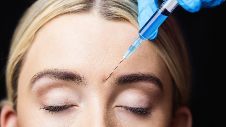 Frau erhält Botox-Spritze in die Stirn. (Foto: IMAGO, IMAGO / YAY Images)