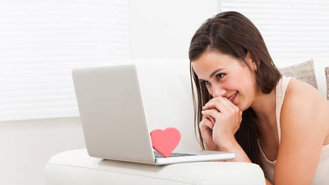 Das Bild zeigt eine Frau, die grinsend auf ihren Laptop schaut. (Foto: IMAGO, Panthermedia)