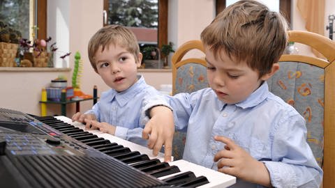 Junge Zwillinge spielen Klavier. (Foto: IMAGO, IMAGO / Torsten Becker)