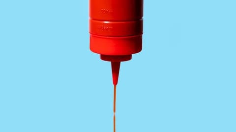 Aus einer Ketchupflasche fließt Ketchup. (Foto: IMAGO, IMAGO / Addictive Stock)