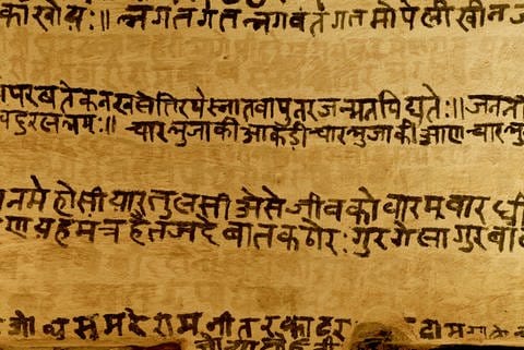 Eine Mauer trägt eine Inschrift auf Sanskrit. (Foto: IMAGO, -)