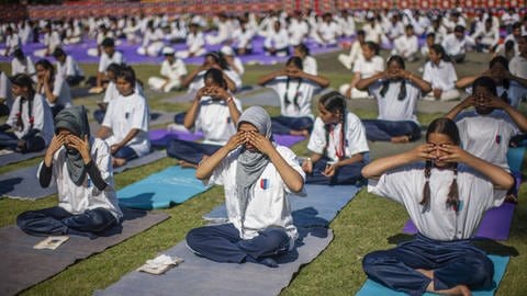 Schülerinnen und Schüler aus Indien machen gemeinsam Yoga. (Foto: IMAGO, -)