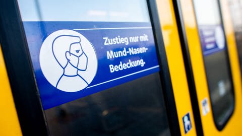 Ein Schild mit der Aufschrift "Zustieg nur mit Mund-Nasen-Bedeckung" an der Zugtür einer Regio-S-Bahn.