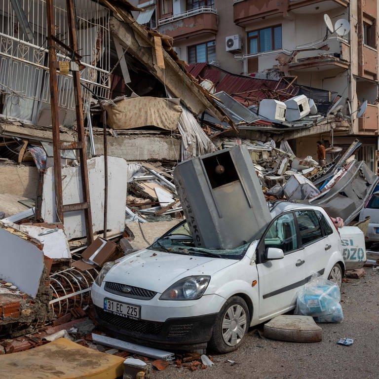 Das Bild zeigt die Folgen des Erdbebens in der Grenzregion TürkeiSyrien: Zerstörte Gebäude, Autos und Straßen.