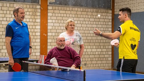 Das Bild zeigt Menschen, die an Parkinson erkrankt sind, beim Tischtennis spielen.