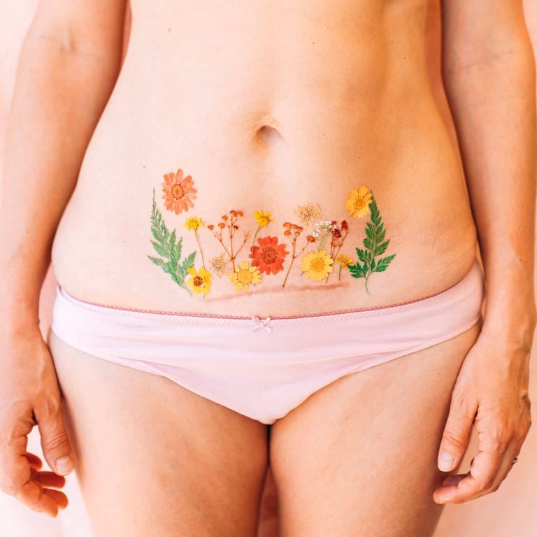 Mutter zeigt ihre Kaiserschnittnarbe mit einer Körperbemalung (Foto: IMAGO, /Westend61)