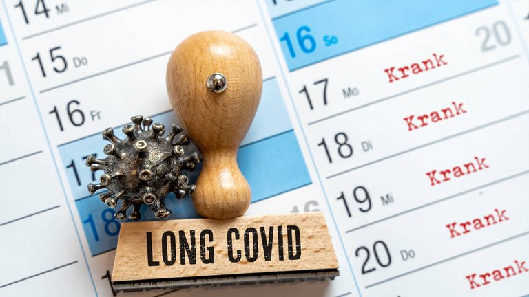 Kalender mit einem Long Covid Stempel. Eingetragen sind Krankheitstage. Manche Menschen können aufgrund ihrer Beschwerden nicht mehr zur Arbeit gehen. (Foto: IMAGO, /Bihlmayerfotografie)