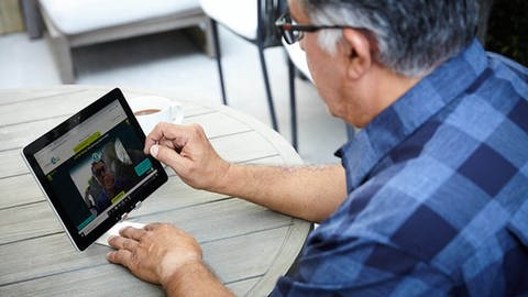 Das Bild zeigt einen Mann am Tablet, der die Software von "StoryFile" ausprobiert.