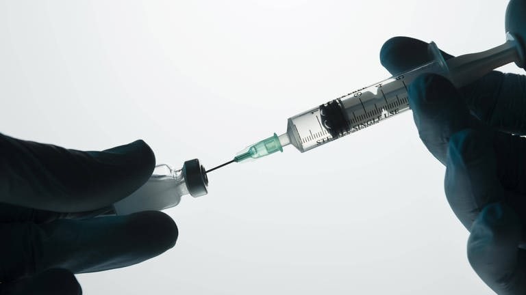 Das Bild zeigt eine Impfspritze, die aufgezogen wird. (Foto: IMAGO, imagebroker)