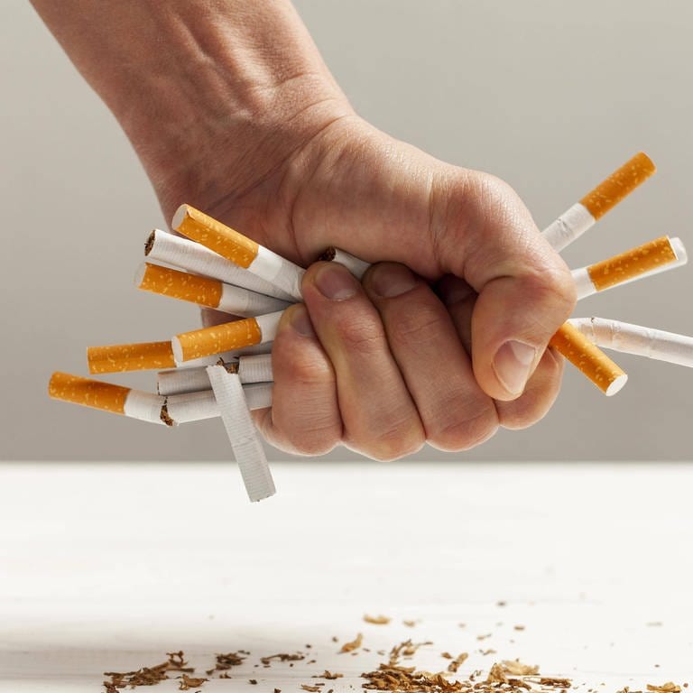 Zigaretten werden in Hand zerdrückt