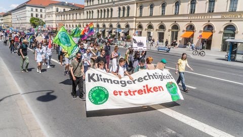 Das Bild zeigt Jugendliche auf einer Klima-Demo. Sie tragen ein Banner mit der Aufschrift "Klimagerechtigkeit erstreiken".
