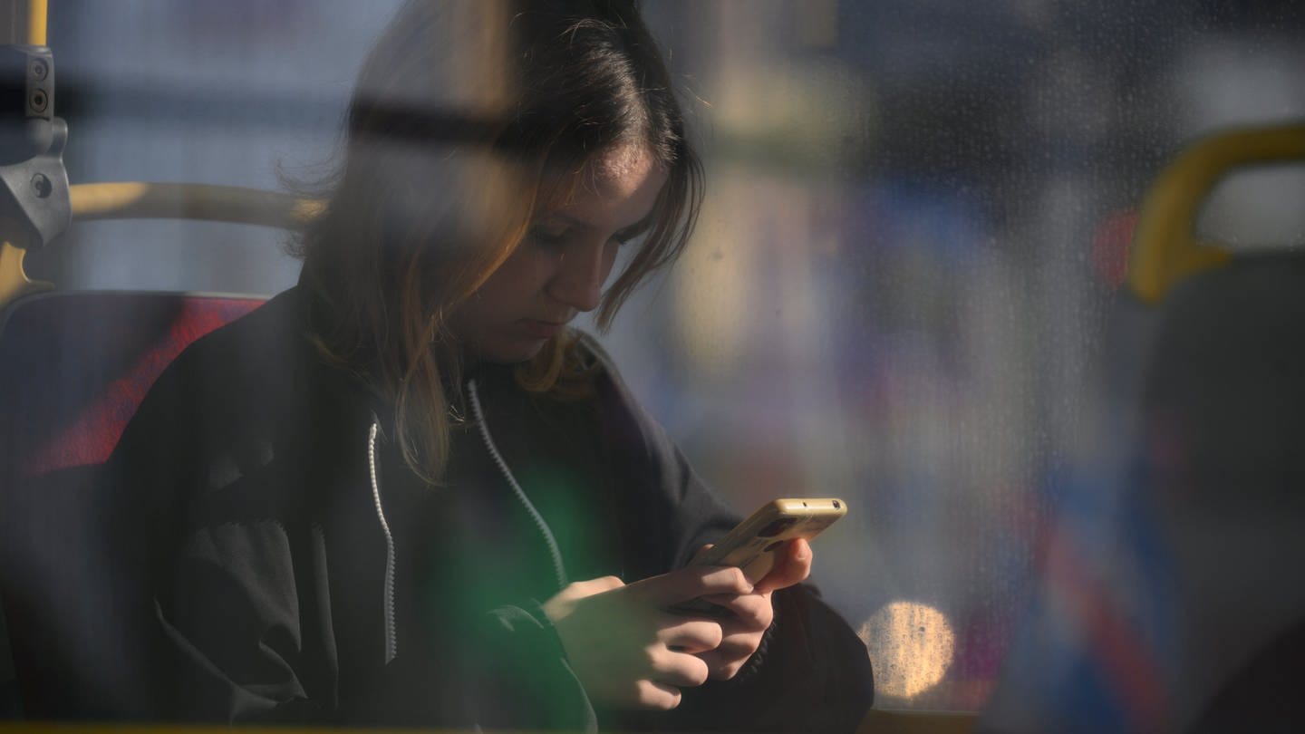 Frau schaut auf ihr Handy. (Foto: picture-alliance / Reportdienste, picture alliance / NurPhoto | Jaap Arriens)