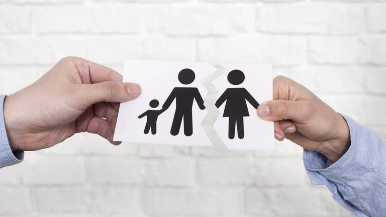 Das Bild zeigt eine zerrissene Zeichnung einer Familie. Links ein Mann und ein Kind, rechts eine Frau.