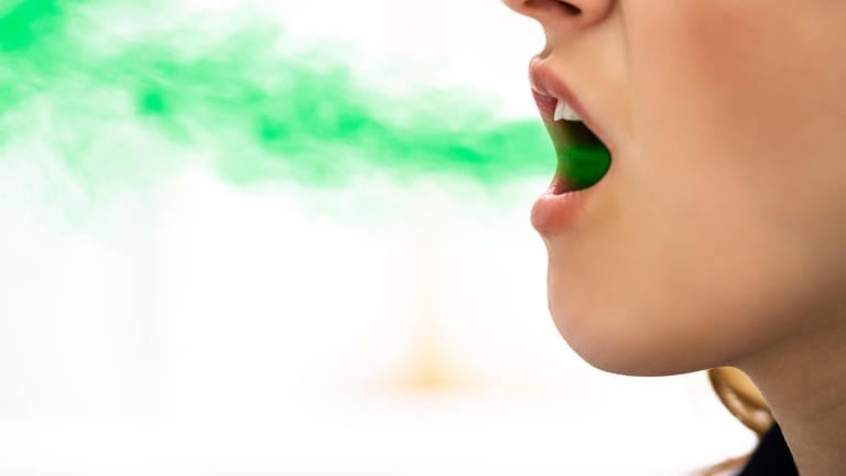 Das Bild zeigt eine grüne Wolke, die Gestank symbolisieren soll, die aus einem Mund kommt.