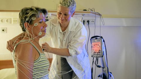 Patientin werden Elektroden für Schlafuntersuchungen angelegt (Foto: IMAGO, IMAGO / Rainer Weisflog)