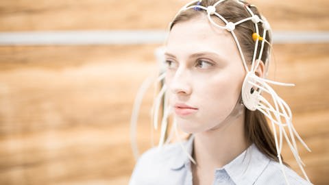 Eine Frau trägt Elektroden auf dem Kopf