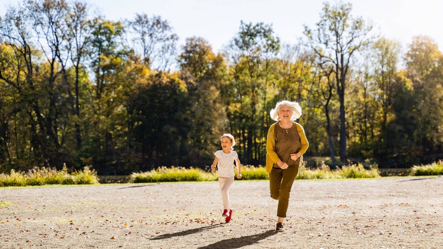 Das Bild zeigt eine ältere Frau und ein kleines Mädchen, die nebeneinander laufen. (Foto: IMAGO, Westend61)