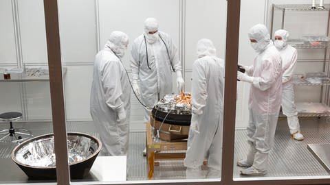 Wissenschaftler arbeiten an der Probenkapsel in einem Cleanroom. (Foto: Pressestelle, NASA/Keegan Barber)