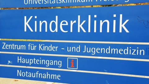 Das Bild zeigt ein Wegweiser-Schild an der Kinderklinik in Freiburg.