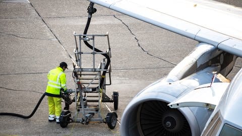 Das Bild zeigt ein Flugzeug, dass von einem Mann betankt wird. Symbolbild: Kerosin, fossile Treibstoffe, Bio-Kraftstoff als Alternative für die Zukunft, Elektromobilität, E-Fuels