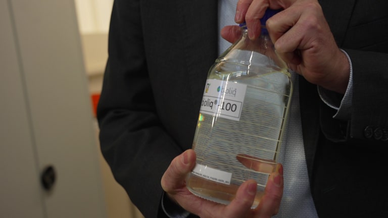 Das Bild zeigt Herrn Prof. Jörg Sauer vom KIT, der eine Flasche Bioliq-Benzin in den Händen präsentiert. Tags: Elektromobilität, E-Fuels