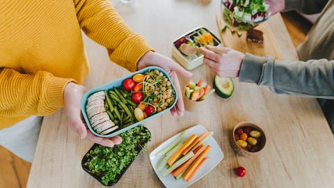 Zu einer gesunden Ernährung gehören lebensmittel wie Gemüse, Hülsenfrüchte und Obst. Denn die zur Krebsprävention wichtigen Ballaststoffe kommen fast ausschließlich in pflanzlichen Nahungsmitteln vor. Symbolbild: Gemüse und Obst auf einem Tisch (Foto: IMAGO, IMAGO/ Westend61)