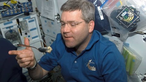 Wenn Essen an Bord schon schwer ist, wie wird es erst bei der Zubereitung von Teig. Hier versucht sich Astronaut Steve Frick an Bord von Space Shuttle Atlantis. (Foto: IMAGO, imago images / UPI Photo)