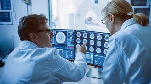 Arzt und Radiologe besprechen Diagnose eines CT-Scans (Foto: Getty Images, Getty Images - gorodenkoff)