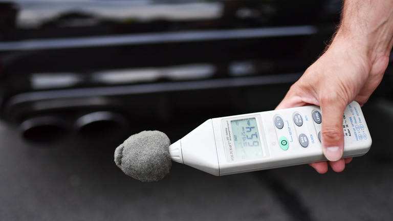 Dezibel-Messgerät vor einem Autoauspuff (Foto: picture-alliance / Reportdienste, picture alliance / Uwe Anspach/dpa)