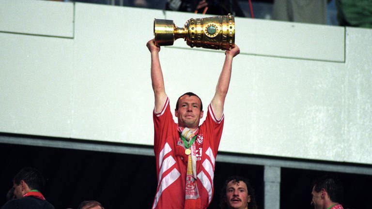 1996: Axel Roos streckt den Pokal in die Höhe. Es ist der zweite Sieg des FCK im zweiten DFB-Pokalfinale im Berliner Olympiastadion. Gegen den KSC gewinnt Kaiserslautern dank des Treffers von Martin Wagner mit 1:0.