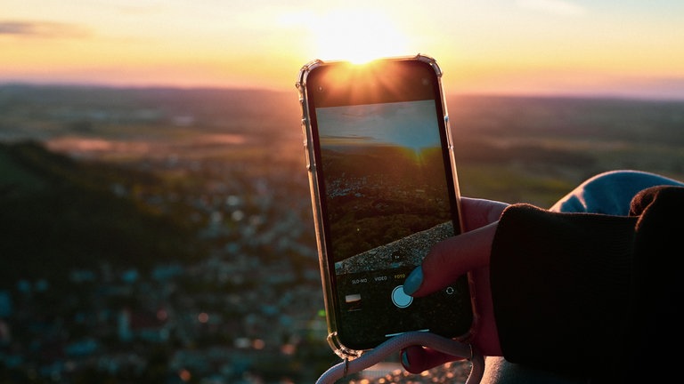 Smartphone fotografiert Landschaft  (Foto: picture-alliance / Reportdienste, picture alliance / Ostalb Network | Marius Bulling)